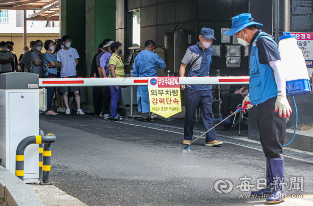 코로나19 일일신규 확진자가 10만 명에 육박하면서 97일 만에 최다치를 기록한 지난 26일 오전 대구 동구보건소 선별진료소 앞에서 보건소 관계자가 방역 작업을 하고 있다. 안성완 기자 asw0727@imaeil.com