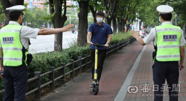 대구 달서구 신당네거리 인근에서 경찰이 전동킥보드를 탄 사람을 단속하고 있다. 매일신문DB