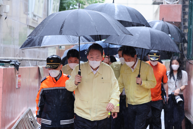 윤석열 대통령이 9일 발달장애인 가족이 폭우로 인한 침수로 고립돼 사망한 서울 관악구 신림동 침수 한 다세대주택을 방문한 뒤 다른 피해 현장으로 이동하고 있다. 연합뉴스