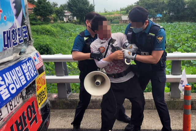 경남 양산경찰서 경찰관들이 16일 문재인 전 대통령 비서실 인사를 커터칼로 협박하는 등 소란을 피운 평산마을 장기 1인 시위자를 특수협박 혐의로 체포하고 있다. 연합뉴스