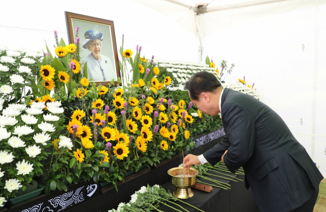 엘리자베스 2세 영국 여왕이 방문했던 안동 하회마을 충효당 앞에는 여왕의 서거를 추모단이 마련돼 추모와 애도하는 관광객들이 이어졌다. 사진은 11일 권기창 안동시장이 여왕의 서거를 추모하고 있다. 안동시 제공