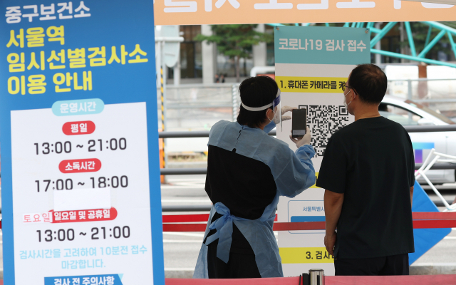 추석 연휴 사흘째인 11일 오후 서울역 앞에 마련된 코로나19 선별검사소에서 관계자가 시민을 안내하고 있다. 연합뉴스