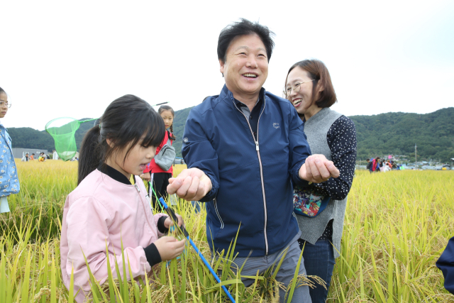 이병환 성주군수(가운ㄷ)가 2019년 열린 메뚜기 축제 현장에서 참여자들과 메뚜기를 잡고 있다. 성주군 제공