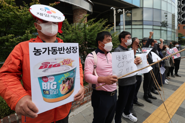 전국농민회총연맹 등 농민단체 회원들이 23일 오전 서울 중구 CJ제일제당 본사 앞에서 기자회견을 열고 국산 쌀값 폭락 등으로 인한 농가의 어려움을 호소하며 일부 즉석밥 제품에 수입산 쌀 사용을 규탄하고 있다. 연합뉴스