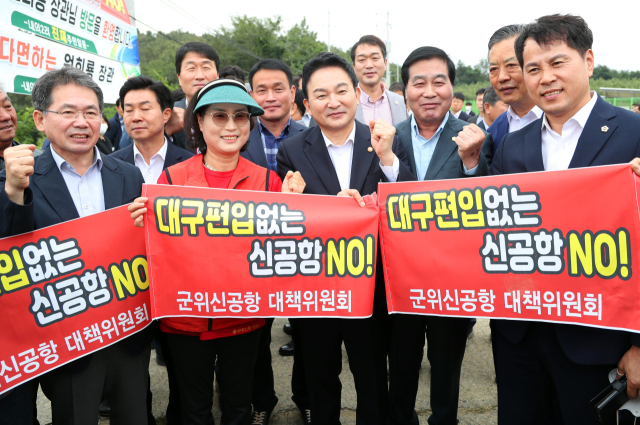 원희룡 국토교통부 장관이 지난 9월 대구경북 통합신공항 부지인 경북 군위군 소보면 내의리를 방문해 현장을 살펴봤다. 이후 지역 주민 및 관계자들과 통합신공항 건설에 따른 군위군의 대구 편입을 촉구하는 현수막을 들고 파이팅을 하고 있다. 연합뉴스