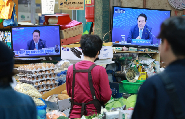 27일 오후 서울 서대문구 인왕시장에서 장을 보러온 시민들이 오가고 있다. 상점 TV 화면에 윤석열 대통령 주재 비상경제민생회의가 생중계로 방송되고 있다. 연합뉴스