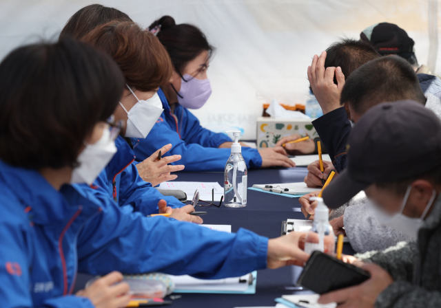 26일 서울 종로구 조계사 대웅전 앞에서 열린 종로구＆조계사 취업박람회에서 구직자들이 취업 상담을 받기 위해 서류를 작성하고 있다. 연합뉴스