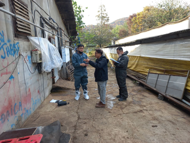 경북 군위군 축산악취저감 TF팀과 전문 업체가 축산 농장을 방문, 농장 관계자의 설명을 듣고 있다. 군위군 제공