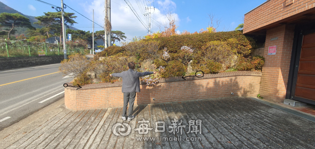 도상열 남원1리 이장이 개인이 국·공유 도로 부지를 무단 점용해 화단을 만든 부분(화살표 내)을 설명하고 있다. 이 주택은 출입구 부분만 점용허가를 받았다. 이영욱 기자