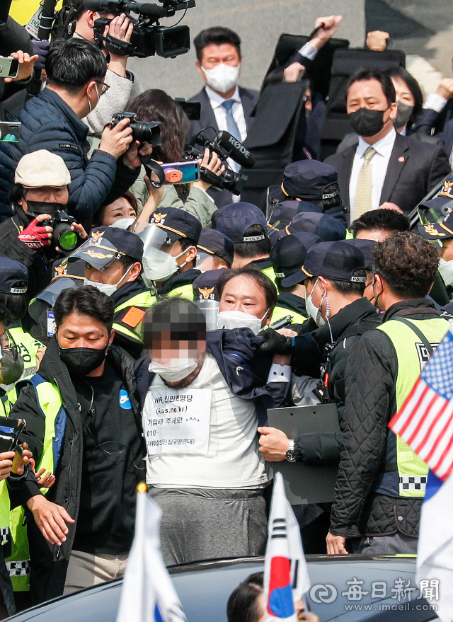 지난 3월 24일 낮 대구 달성군 사저에 도착한 박근혜 전 대통령을 향해 소주병을 던진 남성이 경찰에 연행되고 있다. 우태욱 기자 woo@imaeil.com