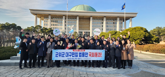 김진열 경북 군위군수와 직원, 박수현 군위군의회 의장과 의원들이 국회 본회의에서 대구 편입 법률안이 통과된 후 국회 앞에서 기념 사진을 촬영하고 있다. 군위군 제공