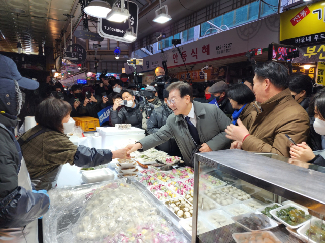 22일 경북 안동 중앙신시장을 찾은 이재명 더불어민주당 대표가 상인 손을 잡고 인사하며 대화를 나누고 있다. 김영진 기자