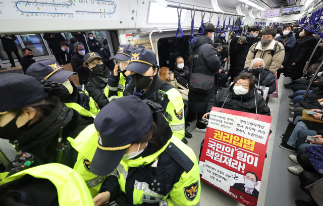 전국장애인차별철폐연대 회원들이 19일 오전 서울 지하철 1호선 용산역에서 지난 14일 지하철 탑승 시위 중 무정차 통과 조치에 규탄하며 기습시위를 하고 있다. 연합뉴스