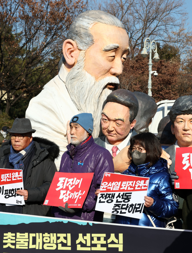 4일 오전 서울 용산구 전쟁기념관 앞에서 열린 2023년 윤석열 정권 퇴진 규정 촛불대행진 선포식에서 촛불행동 관계자들이 손팻말을 들고 있다. 연합뉴스