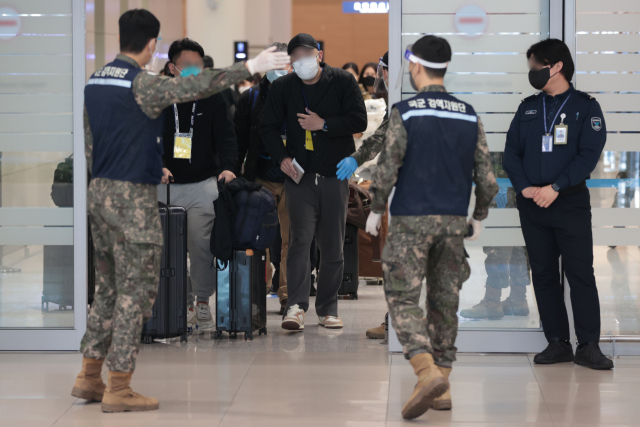 9일 오전 인천국제공항 제2여객터미널에서 방역 관계자들이 중국발 입국자들을 코로나19 검사센터로 인솔하고 있다. 연합뉴스