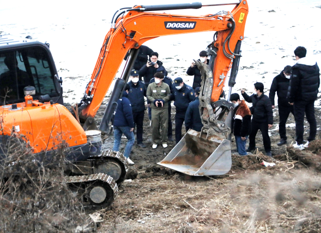 택시 기사와 동거녀를 살해한 혐의로 구속된 이기영이 6일 오후 경기도 파주 공릉천변에서 검찰 관계자들과 현장검증을 하고 있다. 연합뉴스