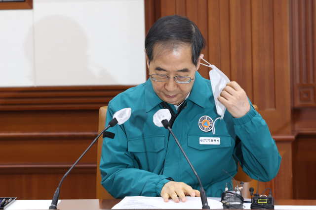 한덕수 국무총리가 20일 오전 정부서울청사에서 열린 코로나19 중앙대책본부 회의에서 마스크를 벗고 있다. 연합뉴스