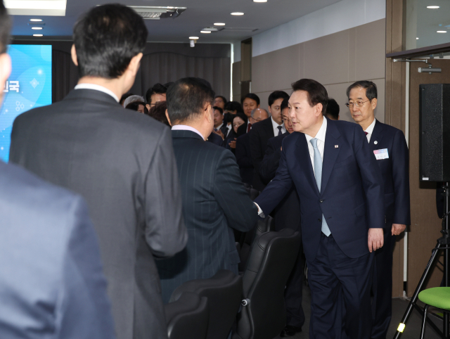 윤석열 대통령이 1일 경상북도 구미시 금오공과대학교에서 열린 제1차 인재양성전략회의에 입장하며 참석자들과 인사를 나누고 있다. 연합뉴스