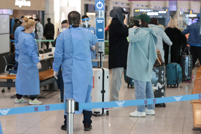 중국발 단기비자 발급 재개를 하루 앞둔 10일 인천국제공항 제1여객터미널에서 중국발 입국자들이 의료진 안내를 받고 있다. 연합뉴스