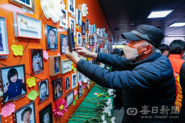 대구지하철참사 20주기를 하루 앞둔 17일 세월호와 가습기 살균제 등 전국 재난 참사 피해자 가족들이 기자회견을 가진 중앙로역 추모의벽 앞에서 지하철참사 유족이 희생자들의 사진을 바라보고 있다. 이들은 