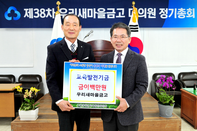 경북 군위군 홍유석(왼쪽) 우리새마을금고 이사장이 김진열 군수에게 교육발전기금을 기탁하고, 기념 사진을 촬영하고 있다. 군위군 제공