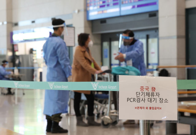 지난달 12일 인천국제공항 제1터미널에서 중국발 입국자가 pcr 검사 관련 안내를 받고 있다. 연합뉴스