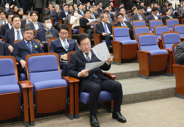 더불어민주당 이재명 대표가 21일 오후 국회에서 열린 의원총회에서 당 전략기획위원회의 여론조사 분석 동향 자료를 살펴보고 있다. 연합뉴스