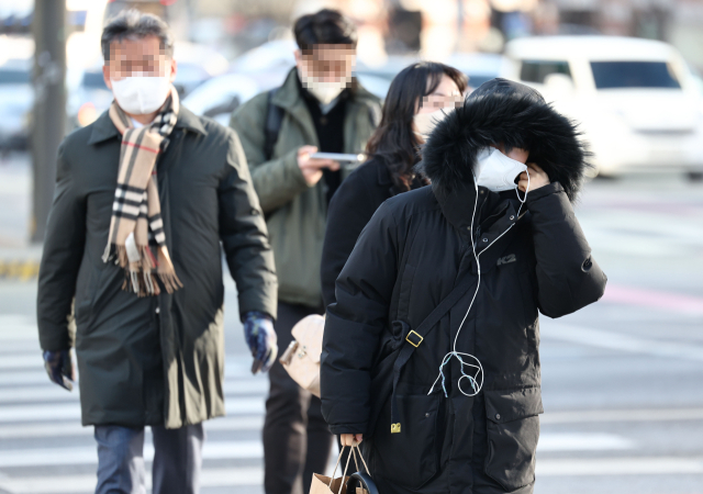 아침 기온이 큰 폭으로 떨어져 추운 날씨를 보이는 13일 오전 서울 종로구 광화문네거리에서 두꺼운 외투를 입은 출근길 시민들이 이동하고 있다. 연합뉴스