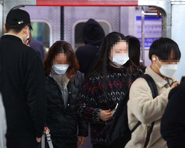 중앙재난안전대책본부의 마스크 착용 의무 범위 재조정을 하루 앞둔 14일 오전 서울 신도림역에서 마스크를 쓴 시민이 지하철에서 내리고 있다. 연합뉴스