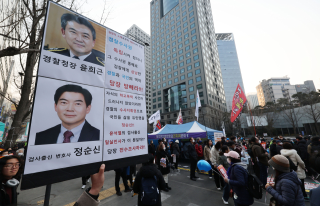 4일 오후 서울 중구 숭례문 앞 대로에서 촛불행동 주최로 열린 29차 촛불대행진에서 한 참가자가 아들의 학교폭력(학폭) 전력이 드러난 정순신 변호사를 규탄하는 손피켓을 들고 있다. 연합뉴스