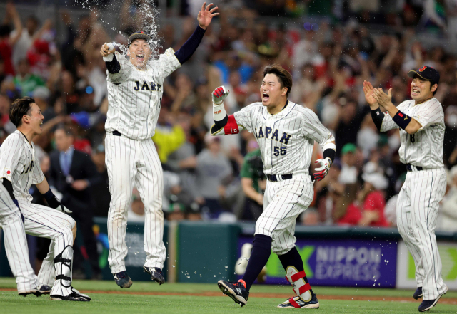 21일 미국 플로리다주 마이애미 론디포 파크에서 열린 일본과 멕시코의 2023 WBC 4강전. 9회말 끝내기 안타를 쳐낸 무라카미가 동료들의 축하를 받고 있다. 연합뉴스