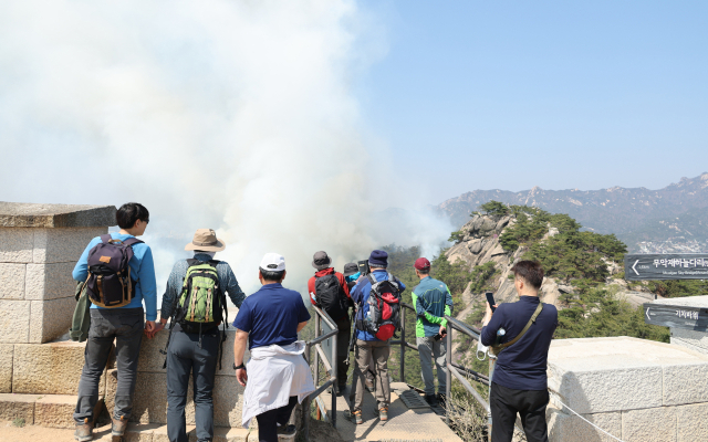 2일 오후 서울 인왕산에서 산불이 발생, 등산객들이 안타깝게 화재 현장을 바라보고 있다. 연합뉴스