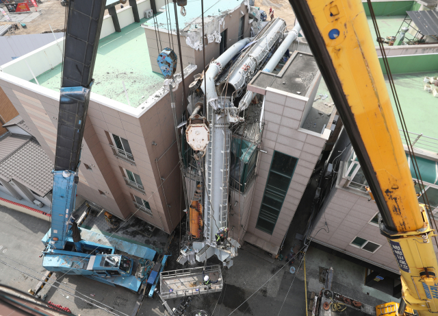 지난 3월 29일 울산시 남구 한 아파트 공사 현장에서 천공 중장비인 항타기가 넘어져 인근 원룸 건물을 덮친 가운데 이튿날인 30일 오후 항타기를 해체하는 작업이 이뤄지고 있다. 연합뉴스