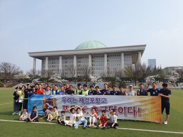 재경포항고총동창회 축구 소모임 회원들이 서울 여의도 국회 본관을 배경으로 기념촬영을 하고 있다. 재경동창회 제공