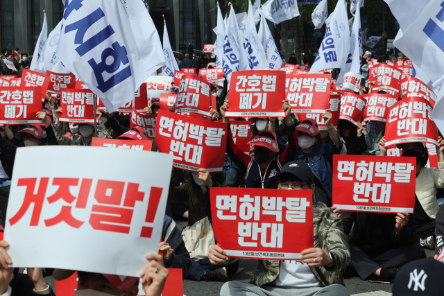 대한의사협회를 비롯한 13개 보건복지의료연대 관계자들이 지난달 16일 서울시청 인근에서 열린 간호법·면허박탈법 저지 400만 보건복지의료연대 총파업 결의대회에서 관련 구호를 외치고 있다. 연합뉴스