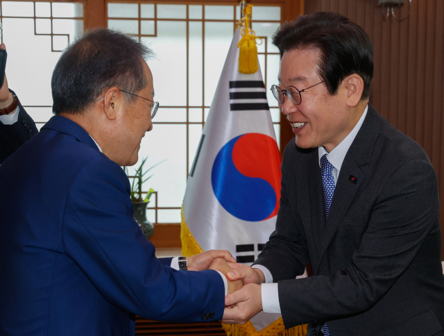 이재명 더불어민주당 대표가 지난해 5월 10일 대구시청 산격청사를 찾아 홍준표 대구시장과 악수하고 있다. 김영진 기자 kyjmaeil@imaeil.com