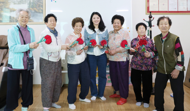 경북 칠곡군 가산면 학산1리 할머니들이 스승의 날을 맞아 한글을 가르치고 있는 성인문해교육 김도현 교사(사진 중앙)에게 카네이션을 전달하고 있다. 칠곡군 제공