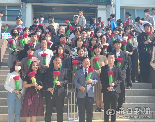 무학중학교 교사들이 15일 스승의 날 기념행사에서 학생들로부터 카네이션을 받고 즐거워 하고 있다. 무학중 제공