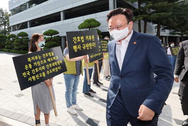 조규홍 보건복지부 장관이 16일 오후 서울 고려대학교 안암병원에서 현장 간담회에 참석하는 가운데 고려대 안암병원 간호사와 전국보건의료산업노동조합 조합원들이 윤석열 대통령의 간호법 제정안에 대한 법률안 거부권 행사를 규탄하며 손팻말을 들고 있다. 연합뉴스