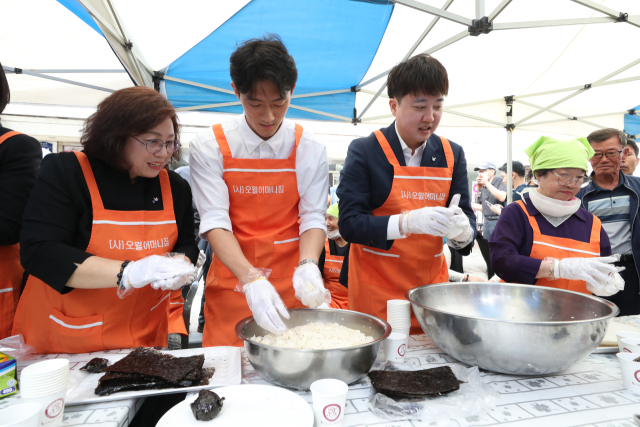 전두환 전 대통령의 손자인 전우원 씨와 국민의힘 이준석 전 대표가 17일 광주 동구 금남로에서 열린 5·18시민난장 오월 주먹밥 체험 부스에서 주먹밥을 만들고 있다. 연합뉴스