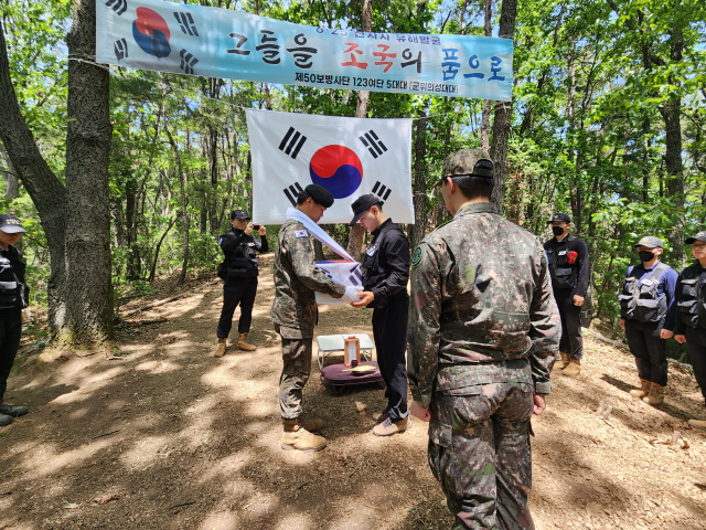 국방부 유해발굴감식단과 육군 50사단 군위·의성대대 장병들이 경북 군위군 효령면 장기리 365고지에서 발굴한 유해의 약식제례를 진행하고 있다. 육군 50사단 제공