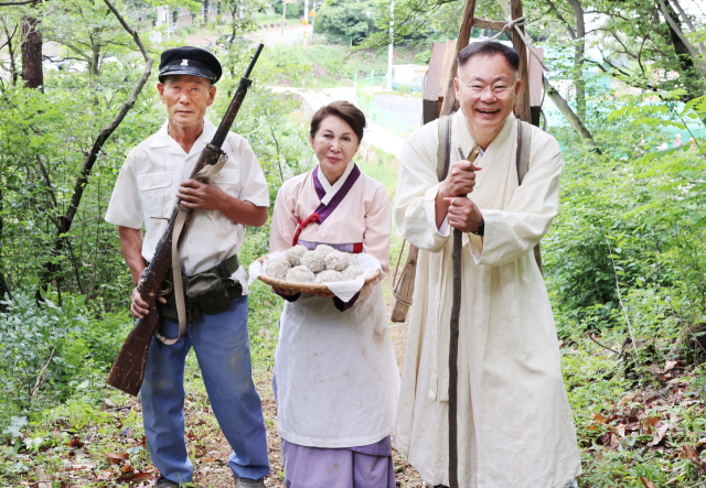 김재욱(오른쪽) 칠곡군수와 백남희(중앙) 씨가 경북 칠곡군 망정리 328고지 지겟길에서 지게 부대 재현 행사를 하고 있다. 칠곡군 제공