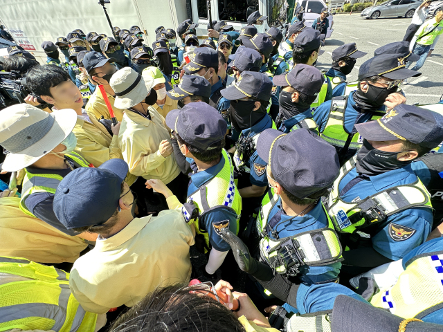 17일 오전 대구 중구 반월당역 인근에서 퀴어문화축제 측 무대차량 진입을 위해 교통 정리에 나선 경찰관들과 이를 막으려는 대구시 공무원들이 대치하고 있다. 연합뉴스