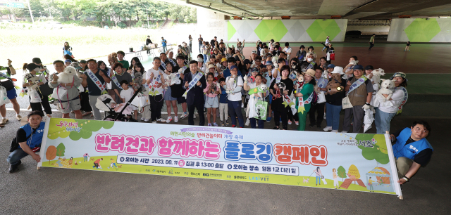 지난 11일 오후 서울 서초구 매헌시민의숲 일원에서 열린 반려견 놀이터 개장 축제에서 시민들과 반려견들이 플로깅(산책하며 쓰레기를 줍는 활동) 행사에 참여하기 전 기념사진을 찍고 있다. 연합뉴스