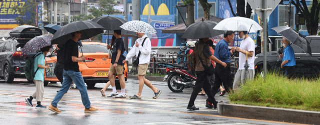 장마가 시작된 26일 오후 우산을 쓴 시민들이 서울 관악구 신림역 인근 횡단보도에서 길을 건너고 있다. 연합뉴스