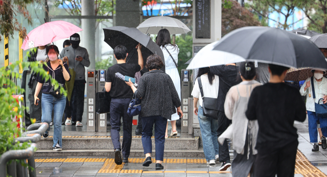 장마가 시작된 26일 오후 서울 관악구 신림역에 우산을 쓴 시민들이 오가고 있다. 연합뉴스