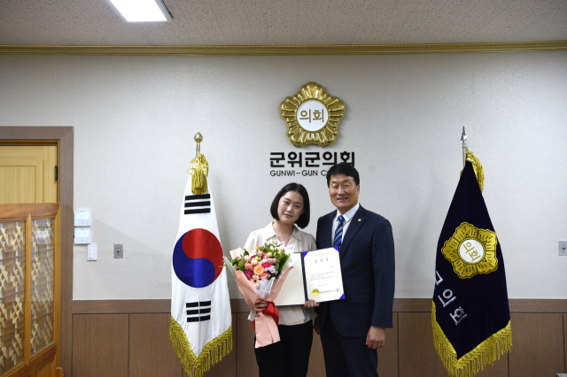 박수현 대구 군위군의회 의장이 신규 임용된 정책지원관에게 임용장을 수여하고, 기념 사진을 촬영하고 있다. 군위군의회 제공