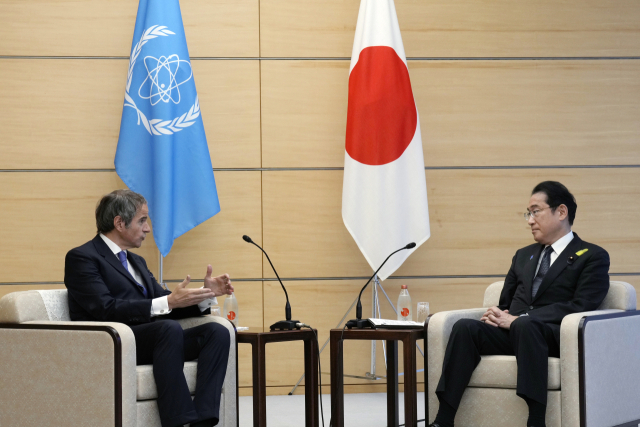 Rafael Mariano Grossi, Director General of the International Atomic Energy Agency, left, speaks with Japanese Prime Minister Fumio Kishida, right, before presenting IAEA\