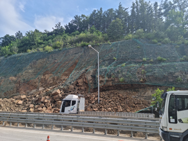 대구시 군위군 효령면 불로리 상주영천고속도로 영천 방향 산사태 현장. 6일 오후 4시 현재 경사면에 10t 정도 되는 암석이 그물망에 걸려 있는 위험한 상태에서 복구작업이 진행되고 있다. 이희대 기자