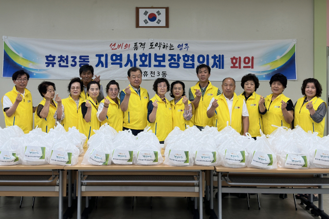 휴천3동 지역사회보장협의체 회원들이 삼계탕 나눔 행사에 앞서 파이팅을 외치고 있다. 영주시 제공